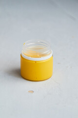 colorful acrylic paint in jar, grey dirty background,  artists materials photography