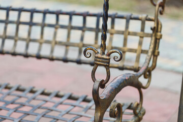 Intricate metalwork shines on a vintage swing bench nestled in a serene garden during a bright...