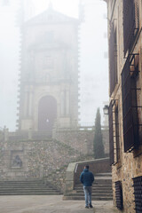 Retrato de un chico joven paseando por el casco antiguo de Cáceres un día con niebla