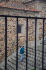 Retrato de un chico joven paseando por el casco antiguo de Cáceres un día con niebla