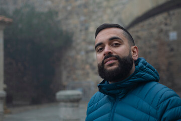 Retrato de un chico joven paseando por el casco antiguo de Cáceres un día con niebla