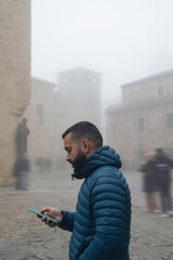 Retrato de un chico joven paseando por el casco antiguo de Cáceres un día con niebla
