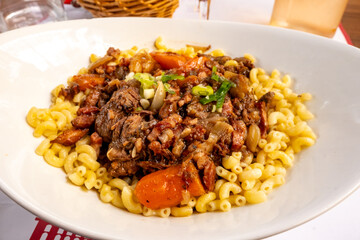 Famous French dish Beef bourguignon with tender pieces of meet, carrots and mushrooms served with cooked pasta in traditional bouillon restaurant in Toulouse, France