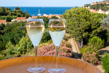 Summer vacation on Mediterranean sea, drinking cold sparkling champagne, cava wine in glass in sunlights, Collioure, Occitanie, South of France, tourists destination