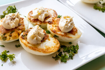 French high cuisine starter dish, pan fried chicken eggs with special filling and yellow sauce, vegetarian food in French restaurant