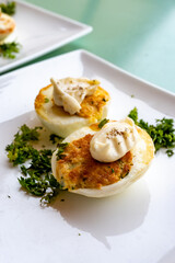 French high cuisine starter dish, pan fried chicken eggs with special filling and yellow sauce, vegetarian food in French restaurant