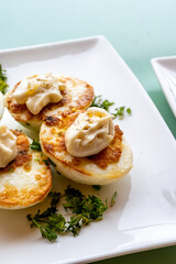 French high cuisine starter dish, pan fried chicken eggs with special filling and yellow sauce, vegetarian food in French restaurant