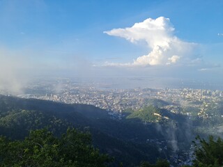 Panoramic view of Rio de Janeiro with mountains, city skyline, and bright blue sky. The photos capture famous landmarks such as Sugarloaf Mountain and the Christ the Redeemer statue in the distance, w
