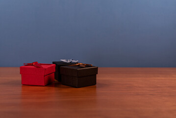 Assorted Gift Boxes on Wooden Table Against Minimal Blue Background