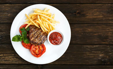 Restaurant food - beef grilled steak isolated at the wooden table, above view