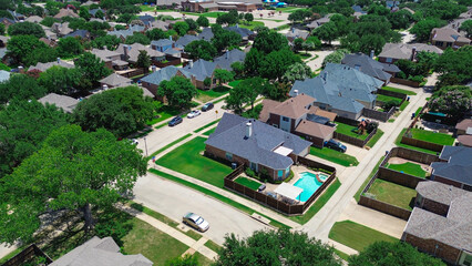 Fototapeta premium Row of large suburban homes in Coppell, Texas with fenced yards, swimming pools, mature trees, located near Cottonwood Elementary School in a walkable, master-planned community suburbs Dallas