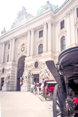 Waiting fiacre carriages on Michaelerplatz in front of the Hofburg Palace in Vienna, Austria