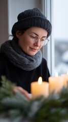 A peaceful woman arranging glowing candles on a windowsill