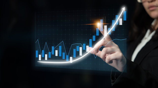 A businesswoman interacts with a digital graph showing stock market trends, illustrating analysis and strategy in a modern office environment focused on growth. Impute