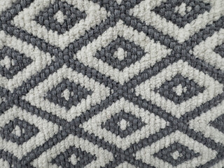 Geometric diamond pattern on a woven grey and white wool rug