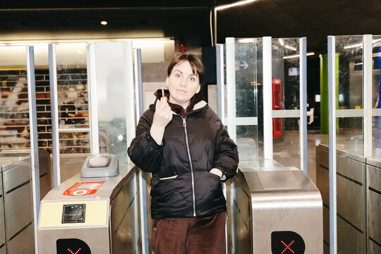 Portrait of a beautiful girl exiting the metro through the turnstile.