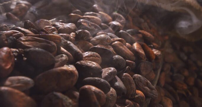 Slow Motion Macro of Steaming Cocoa Beans after Roasting, Evocative Natural Texture and Aroma Rising from Rustic Burlap Sack, Symbol of Authentic Farming and Fine Chocolate Craftsmanship at 1000 fps.