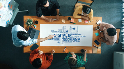 A diverse team of professionals collaborates in a modern office, discussing effective digital marketing strategies surrounded by notes and charts for innovative solutions. Amity