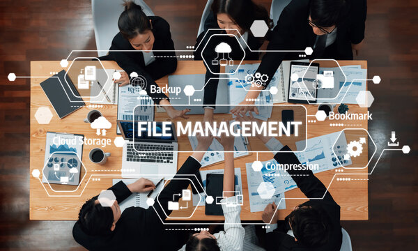A group of professionals engaged in a collaborative meeting focused on file management strategies, utilizing modern technology and digital tools in a workspace setting. Amity