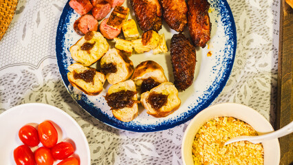 Beautiful served barbecue plate with grilled garlic bread, juicy sausage and golden chicken wings. Perfect for food content.