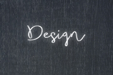 A blackboard with a handwritten chalk message that says design, a powerful symbol of business success and motivation in educational and production concepts.