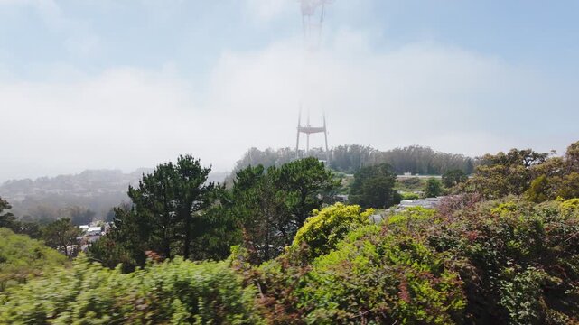 Twin Peaks Reservoir with turquoise water and Sutro Tower rising above trees in San Francisco, California, USA. Scenic urban landmark with greenery, hills and clear summer sky