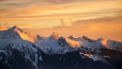 Majestic Snow Capped Mountain Peaks Illuminated By Golden Sunrise Light