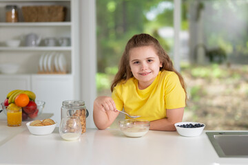 Kids eat healthy food at home. Happy kids eat fresh fruits and vegetables. Cute kids eat meal at kitchen. Kids eat tasty and nutritious breakfast. Children eating fresh fruit salad.