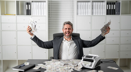 Businessman counting money at his office desk. Banker handling cash and bills in a corporate setting. Accountant organizing dollars and banknotes for finance management.
