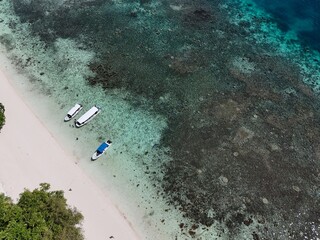 Aerial view of Ulong Island beach and coral reef in Palau with tour boats anchored in turquoise lagoon. National Park in Palau. Chelbacheb © 柏昱 李