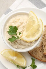 Tasty horseradish sauce with parsley and lemon slices served on light table, top view