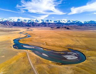 Winding river, golden field, snow-capped peaks under a blue sky