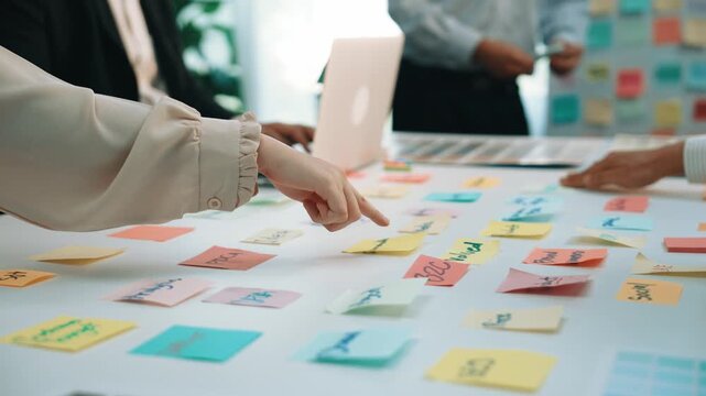 A vibrant brainstorming session combines diverse professionals collaborating on project ideas. Colorful sticky notes scatter across the table, inspiring creativity and teamwork. SACTR