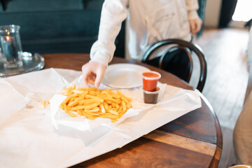 Soft focus shot of teenage boy grabbing hot chip from bundle on table