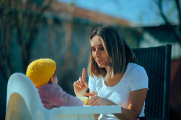 
Mother Saying No to her Baby Teaching Limits. Mom limiting and restricting bad behavior at an...