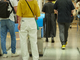 夏の名古屋駅の新幹線改札口を通過する観光客の姿