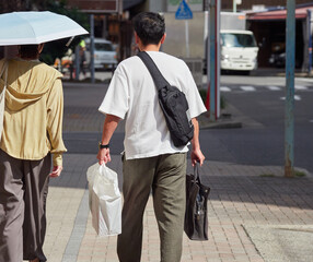 夏の都市の街で歩く男女観光客の姿