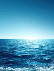 Fototapeta premium The boundless expanse of the deep blue ocean stretches to meet the clear cerulean sky on a bright and sunny day, creating serene seascape.