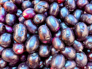 A bunch of purple fruit with a few holes in them