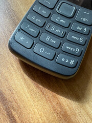 A black cell phone with a keypad on the side