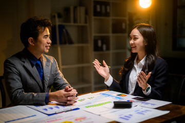 Business colleagues discussing financial data late in office
