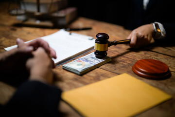 Hand holding gavel above money symbolizing corruption