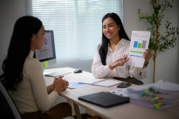 Businesswomen discussing data trends during office meeting