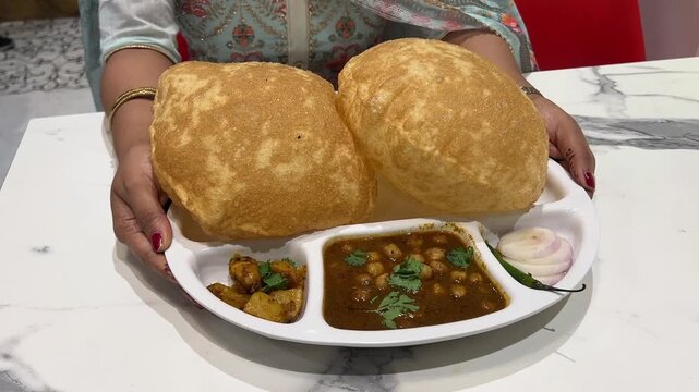 Big size chole bhature served with onion and sabji