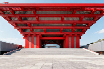 Modern red architectural structure with expansive overhang and symmetrical design