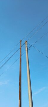 electric utility poles and wires against blue sky