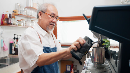 Senior Asian man barista is using a coffee maker. Bakery cafe and coffee shop small business owner concept