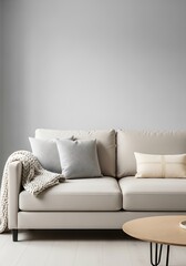 A minimalist living space showcasing a neutral-toned sofa with decorative pillows and a round coffee table