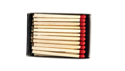 Matchsticks in a box.  Close-up view of several light beige matchsticks neatly arranged in a clear plastic box.  Red heads are visible