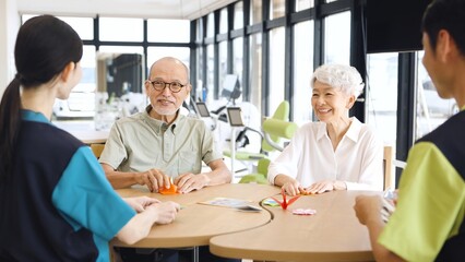 介護施設で折り紙を折るアジア人高齢者
